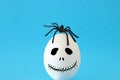 minimal and funny Halloween holiday concept. White egg with scary cute face and spider on top. Royalty Free Stock Photo