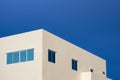 Minimal geometric architecture background of blue glass windows on pale yellow office building against blue clear sky Royalty Free Stock Photo