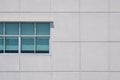 Geometric architecture background of glass windows on large square concrete tiles wall of office building Royalty Free Stock Photo