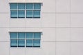 Glass windows on large square concrete tiles wall of office building Royalty Free Stock Photo