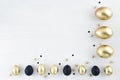 Minimal gold eggs easter concept. Stylish easter golden and black eggs on white wooden background. Flat lay trendy Royalty Free Stock Photo