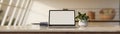 Minimal home workspace tabletop with laptop white screen mockup over blurred living room Royalty Free Stock Photo