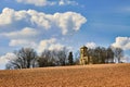Ruins of an old abandoned church with bell tower made of stone between dry trees on a sunny day under dramatic sky Royalty Free Stock Photo