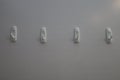 Four plastic hooks on gray wall Royalty Free Stock Photo