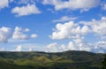 a simple landscape with green rolling hills and white puffy clouds Royalty Free Stock Photo