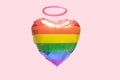 Minimal love concept. Rainbow color heart shaped balloon with pink soft ring above it. Pale lilac pink background