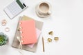 Minimal office desk table with stationery set, coffee cup, earphone and green plant in a pot.