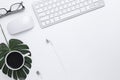 Minimal Office desk table top view with Smart phone, Earphones, Keyboard computer, mouse, Glasses,  coffee cup on a white table Royalty Free Stock Photo