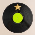 Minimal pop art holiday composition made with vinyl record with green label and gold star against beige background. Creative retro Royalty Free Stock Photo