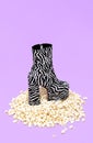 Minimal popcorn background and fashion zebra boots. Still life design. Trendy Fashion Home cinema concept