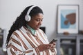 Overweight African American Woman Listenin to Music Indoors