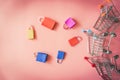 Minimal shopping online concept, Colorful paper shopping bag and trolley go down from floating pink background