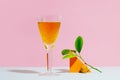 Crystal glass of tangerine juice on coloured background. Summer drink concept. Royalty Free Stock Photo