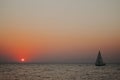 Minimal sun in the setting sun on the sea with a sailboat Royalty Free Stock Photo