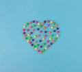 Minimal top view of shaped heart made of candies on blue background. Royalty Free Stock Photo