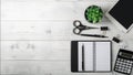 Minimal unisex workplace with tablet, notepad, smartphone, small succulent and accessories on a light wooden background.
