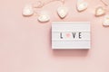 Minimal Valentine flat lay with word love on lightboard and garland. Love concept. Valentine`s day, copy space