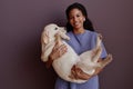 Black young woman holding dog and smiling at camera Royalty Free Stock Photo