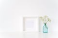 Minimal white square frame mock up with a Aegopodium in transparent blue vase. Mockup for quote, promotion, headline