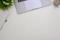 Minimal white workspace with laptop, book, pen, coffee cup, decor plant and copy space. top view Royalty Free Stock Photo