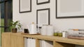 Minimal wood cabinet tabletop with coffee kettle, seasoning bottles and decor over the white wall