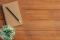 Creative flat lay photo of workspace desk. Office desk wooden table background with mock up notebooks and pencil and plant. Royalty Free Stock Photo