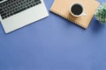 Top view office desk with laptop, notebooks and coffee cup on blue color background. Royalty Free Stock Photo