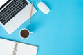Top view office desk with laptop, notebooks and coffee cup on blue color background. Top view with copy space, flat lay photograph Royalty Free Stock Photo