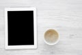 Minimal work space with tablet and latte on white wooden background, top view. Flat lay. Royalty Free Stock Photo