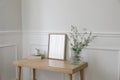 Minimal working space, home office. Elegant corner still life. Cup of coffee, books. Empty vertical picture frame mockup