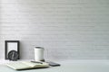 Minimal workplace with picture frame, coffee cup, mobile phone and notebook on white table. Copy space for advertise text or Royalty Free Stock Photo