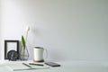 Minimal workplace with picture frame, coffee cup, mobile phone and notebook on white table. Copy space for advertise text or Royalty Free Stock Photo