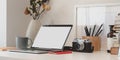 Minimal workspace with laptop computer, camera, office supplies and dry roses vase