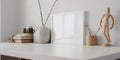 Minimal workspace with mock up frame and office supplies on white wooden table and white wall