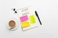 Minimal workspace with notebook, colorful sticky notes, pen, binder clips and coffee cup on white background, top view Royalty Free Stock Photo
