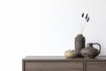 Minimalistic composition of modern living room interior with brown commode, vintage rustic vases and personal accessories.