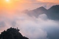 Minimalism photo, hiker at the top of the hill. Fog in the mountains valley. Autumn nature, sunset light in background