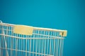 Minimalism style, Shopping cart and blue wall. Royalty Free Stock Photo