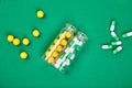 Flat lay overhead of yellow and green pills in glass jar