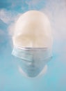 Human face with a mask covered in smoke