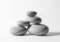 A minimalist arrangement of smooth, gray pebbles forms a balanced stack against a plain white Royalty Free Stock Photo