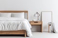 minimalist bedroom with natural wood nightstand and plush white sheets