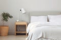 minimalist bedroom with natural wood nightstand and plush white sheets