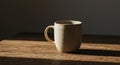 Minimalist beige ceramic coffee mug on rustic wooden surface with shadow Royalty Free Stock Photo