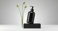 Minimalist Black Dispenser Bottle with Delicate Green Stems on Geometric Pedestal Royalty Free Stock Photo