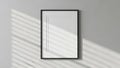 Minimalist black framed picture on a gray wall with light shadows Royalty Free Stock Photo