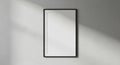 Minimalist black framed rectangle mirror casting subtle shadows on a textured gray wall Royalty Free Stock Photo