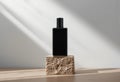 Minimalist Black Rectangular Perfume Bottle on Natural Stone Base with Gradient Background Royalty Free Stock Photo