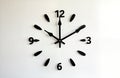 Minimalist black wall clock with round dial, black numbers. Modern style, simple design. Abstract shapes, arrows. Simple design.