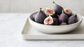 A minimalist bowl of fresh figs placed on a clean white ceramic tray Royalty Free Stock Photo
